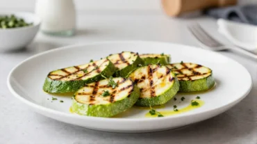 Deliziose zucchine grigliate preparate in friggitrice ad aria, perfette per un contorno leggero.